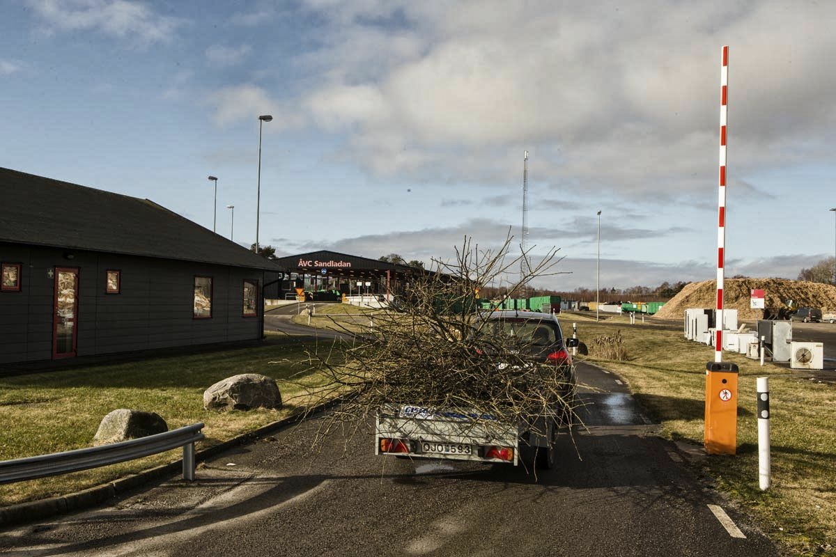 Bil med släp som kör in på en återvinningscentral