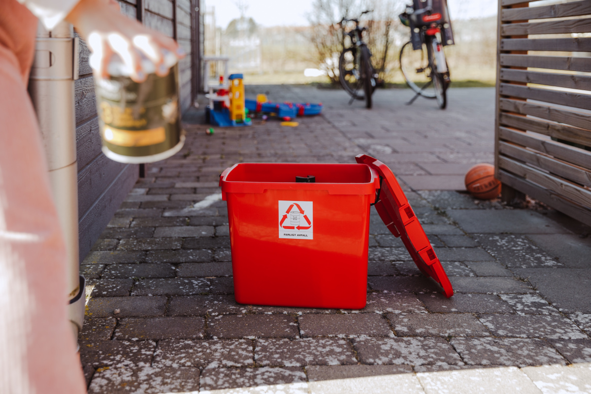 En röd box avsedd för farligt avfall står på marken