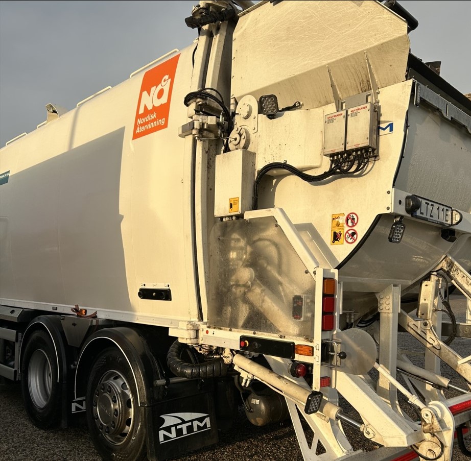 Foto med ett brunt och ett grönt avfallskärl och en snöskyffel