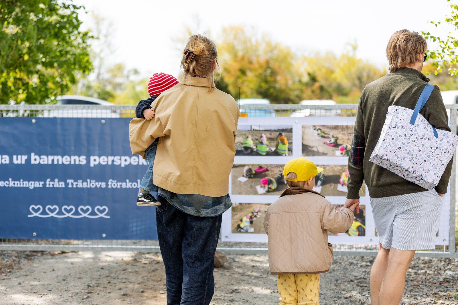 En familj tittar på skyltning på invigningen av Våga