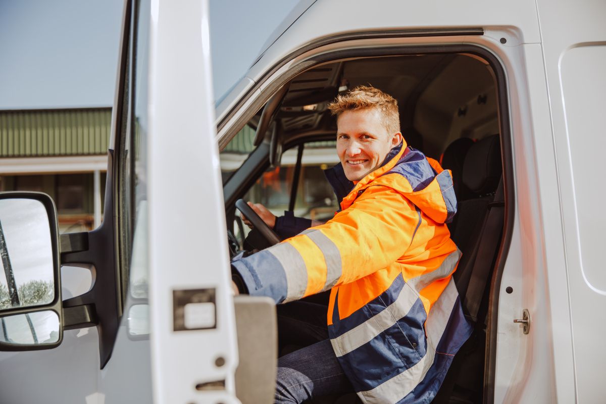 Medarbetare i bil med öppen dörr