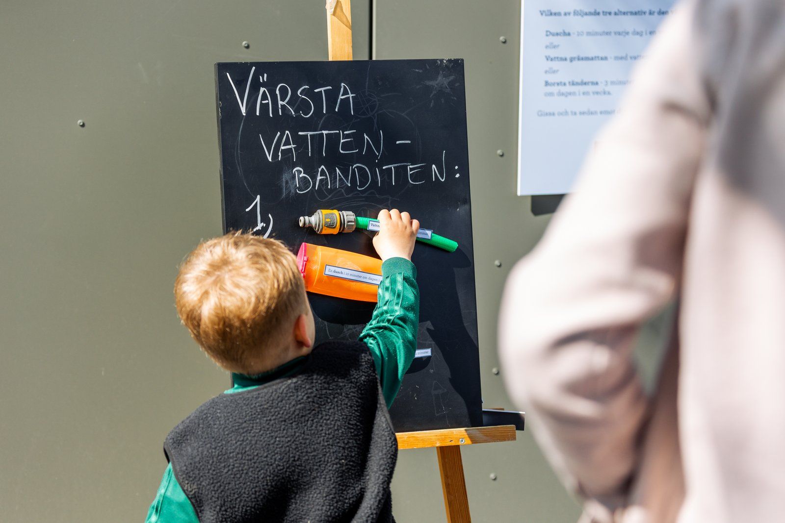 Barn som fäster en vattenslang på ett tavla på invigning av vattentornet Våga