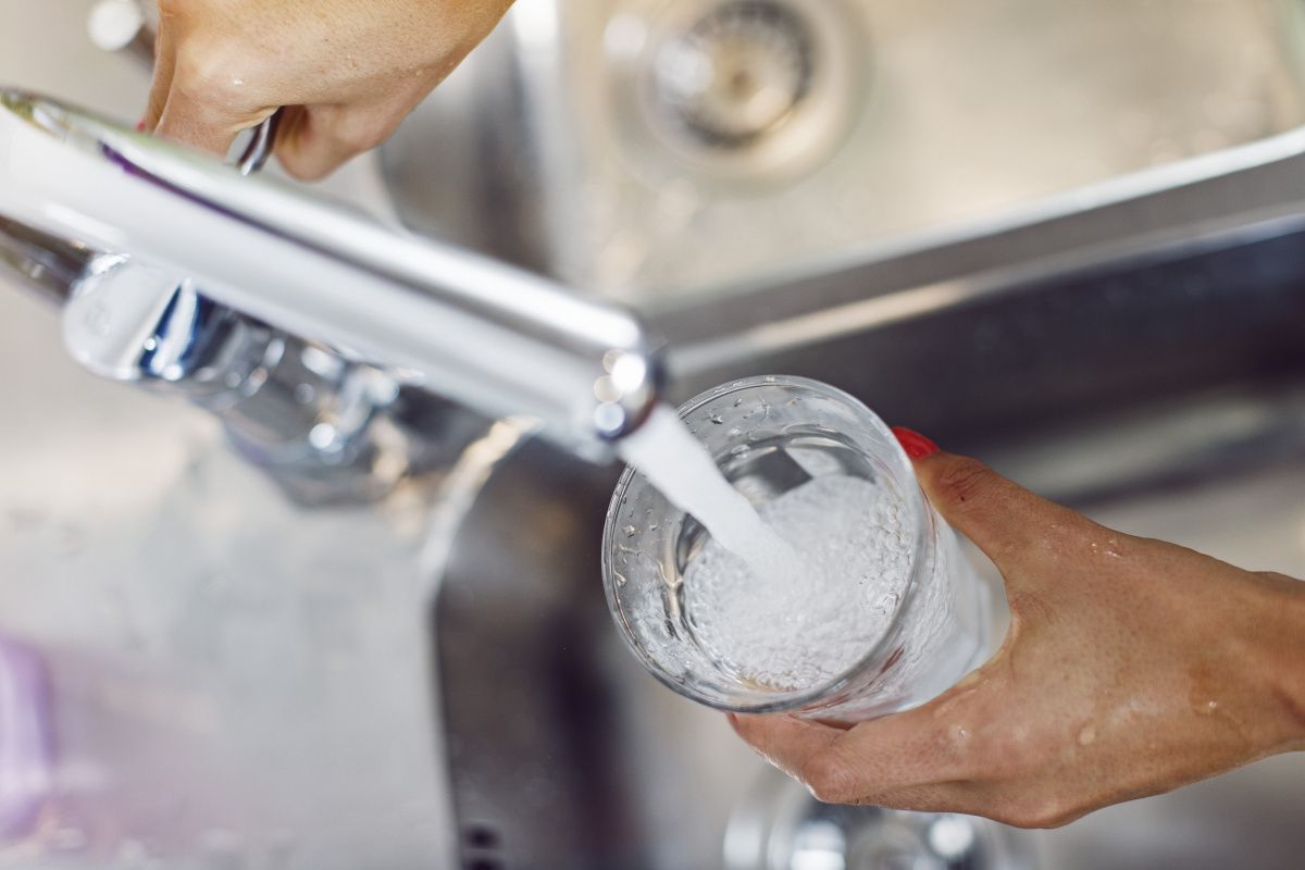 En kran som fyller vatten i ett glas