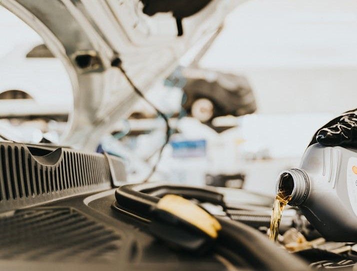 Mekaniker häller olja i bil